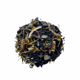 A close-up of Black Lemon tea leaves, showing black tea leaves interspersed with pieces of lemon and lime, and yellowish-brown lemongrass leaves.