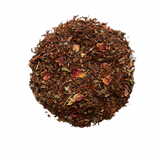 A close-up image of loose leaf tea blend containing pieces of red and dried fruits, and floral petals.