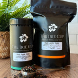 Tea packaging and loose tea on a wooden surface with a plant in the background