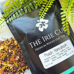 A package of 'The Irie Cup' Peach Honeybush tea with a visible label showing the product name and an image of the tea leaves surrounded by green foliage.