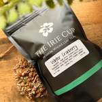 Tea package from 'The Irie Cup' with dried herbs on a wooden surface