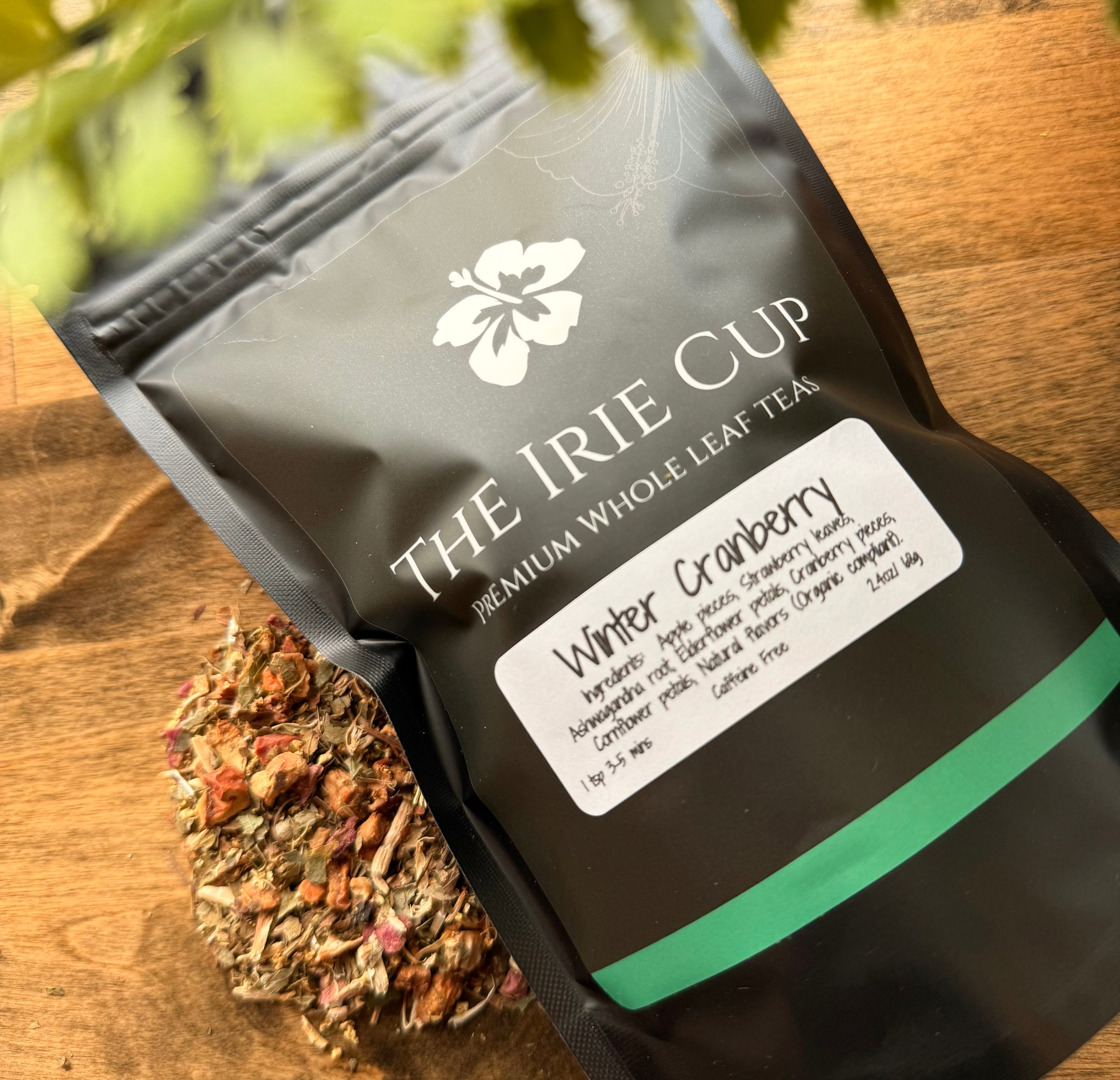 Tea package from 'The Irie Cup' with dried herbs on a wooden surface