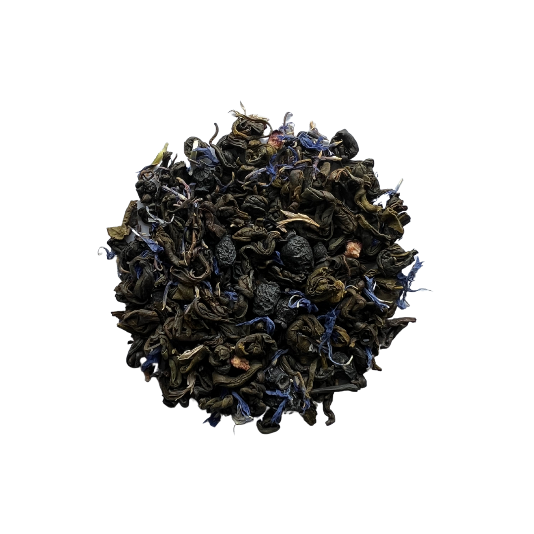 A close-up of dried tea leaves and pieces of blueberries, indicating a green tea blend with blueberry flavor.
