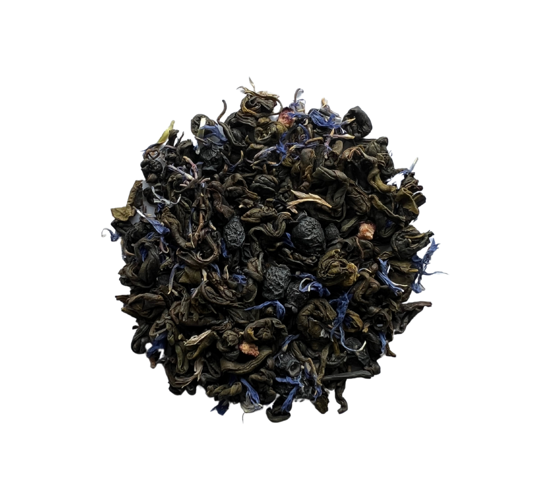 A close-up of dried tea leaves and pieces of blueberries, indicating a green tea blend with blueberry flavor.