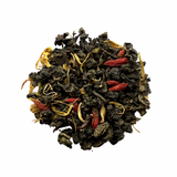 A close-up of dried tea leaves with pieces of watermelon and floral petals visible.